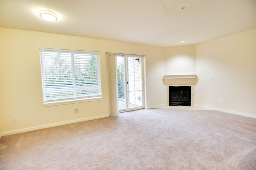 A spacious and empty living room featuring a cozy fireplace and large windows that provide natural light.