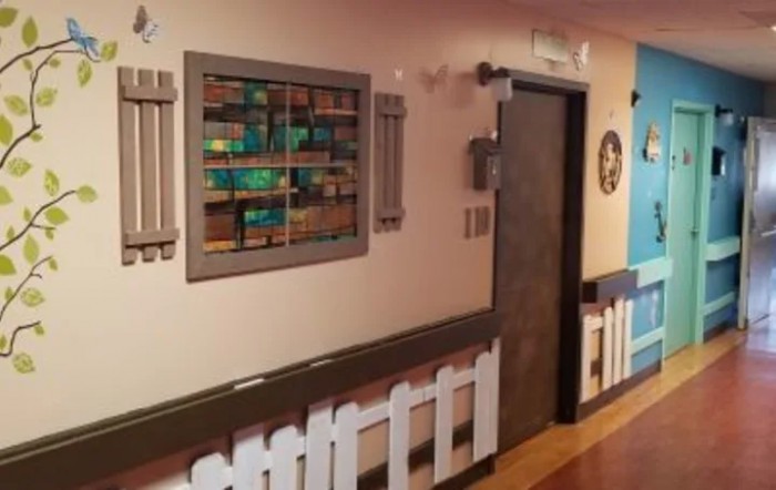 A hallway featuring colorful artwork and decorative elements on the walls.