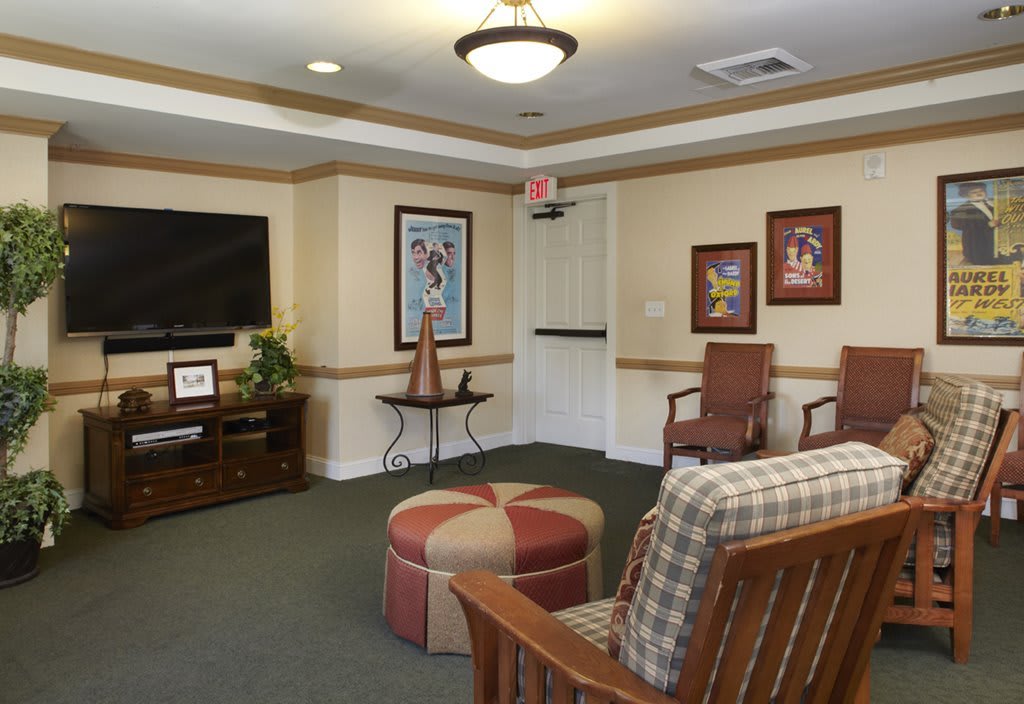 A cozy living room with comfortable seating, a television, and framed artwork on the walls.