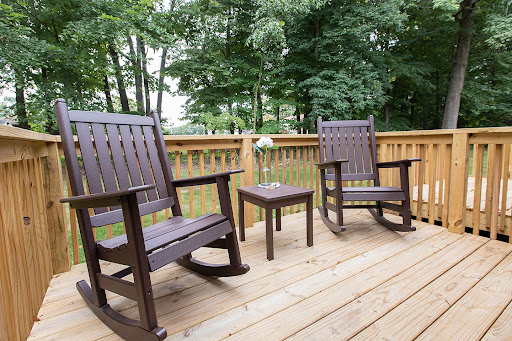 A serene outdoor space featuring two rocking chairs and a small table, perfect for enjoying nature.