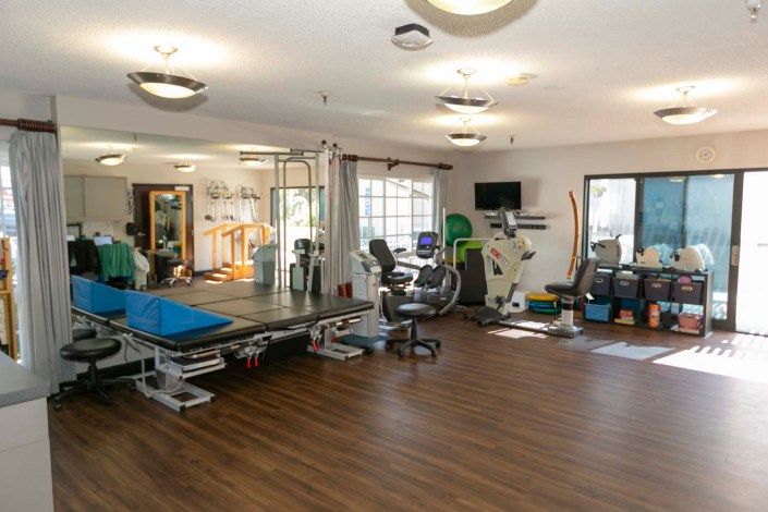 A well-equipped gym with various exercise machines and fitness equipment in a spacious area.