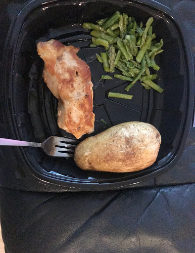 A delicious plate featuring grilled chicken, a baked potato, and steamed green beans.