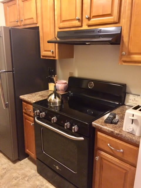 A cozy kitchen with modern appliances including a stove, oven, refrigerator, and toaster.