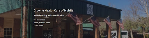 Exterior view of a rehabilitation center in Mobile, showcasing American flags.
