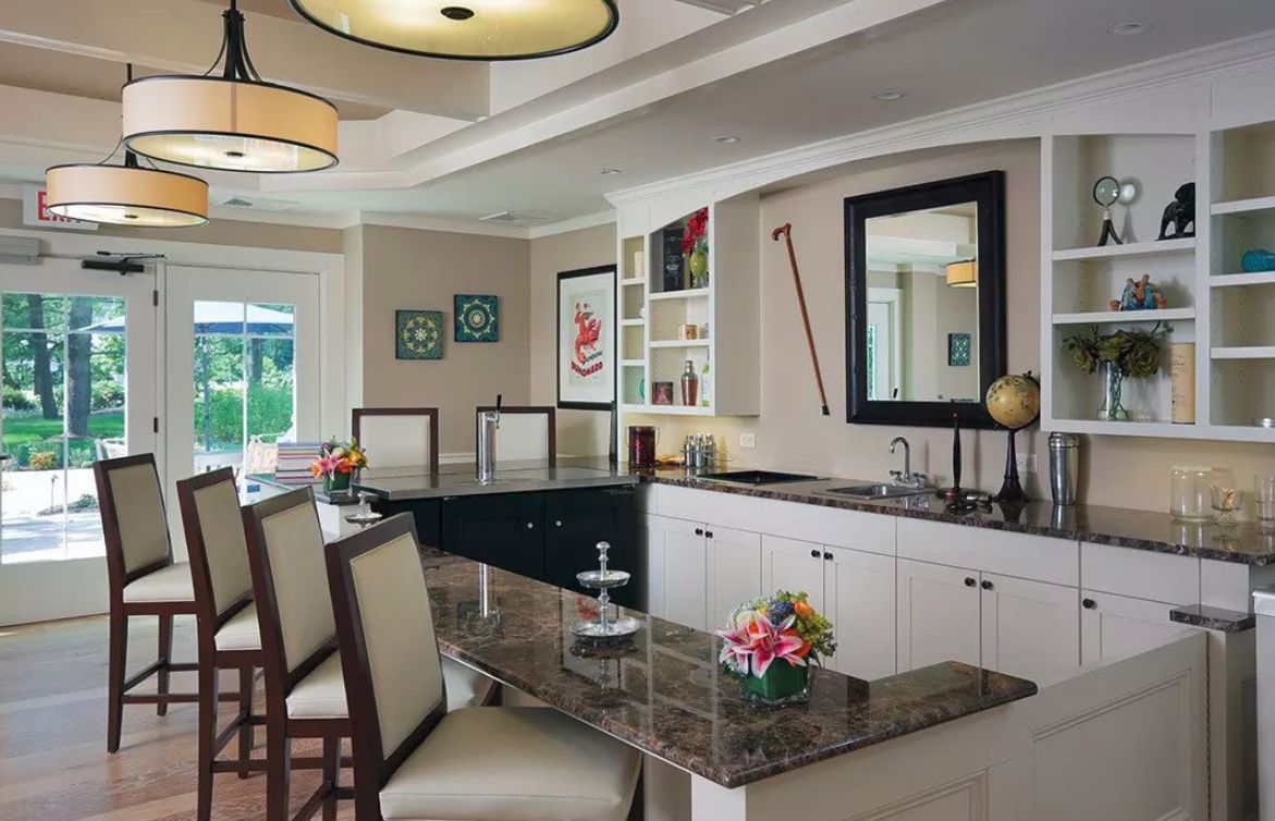 A modern kitchen with an island and bar stools, featuring pendant lighting and elegant decor.