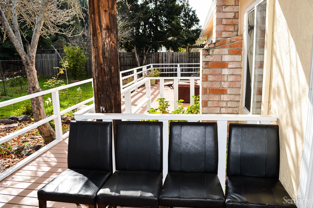 Black chairs arranged on a patio with a view of the yard.