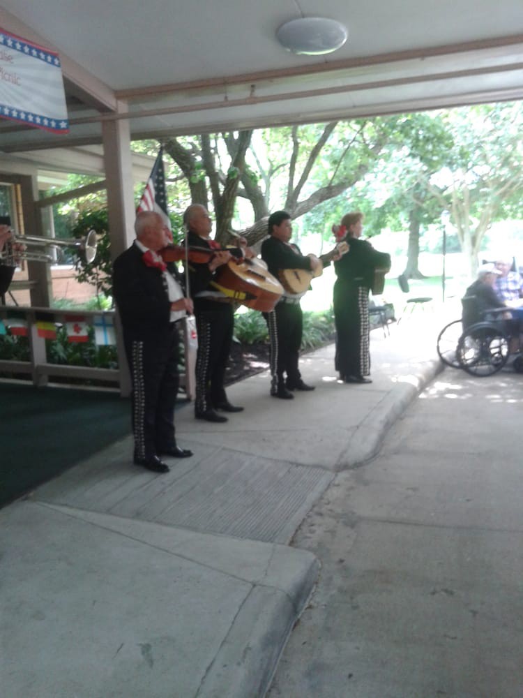 A mariachi band performing outdoors in traditional attire.
