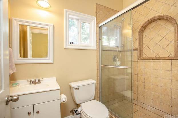 A small bathroom with a shower and toilet.