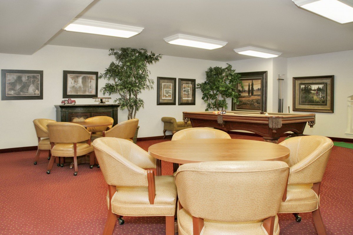 A cozy lounge area with comfortable seating, tables, and decor.