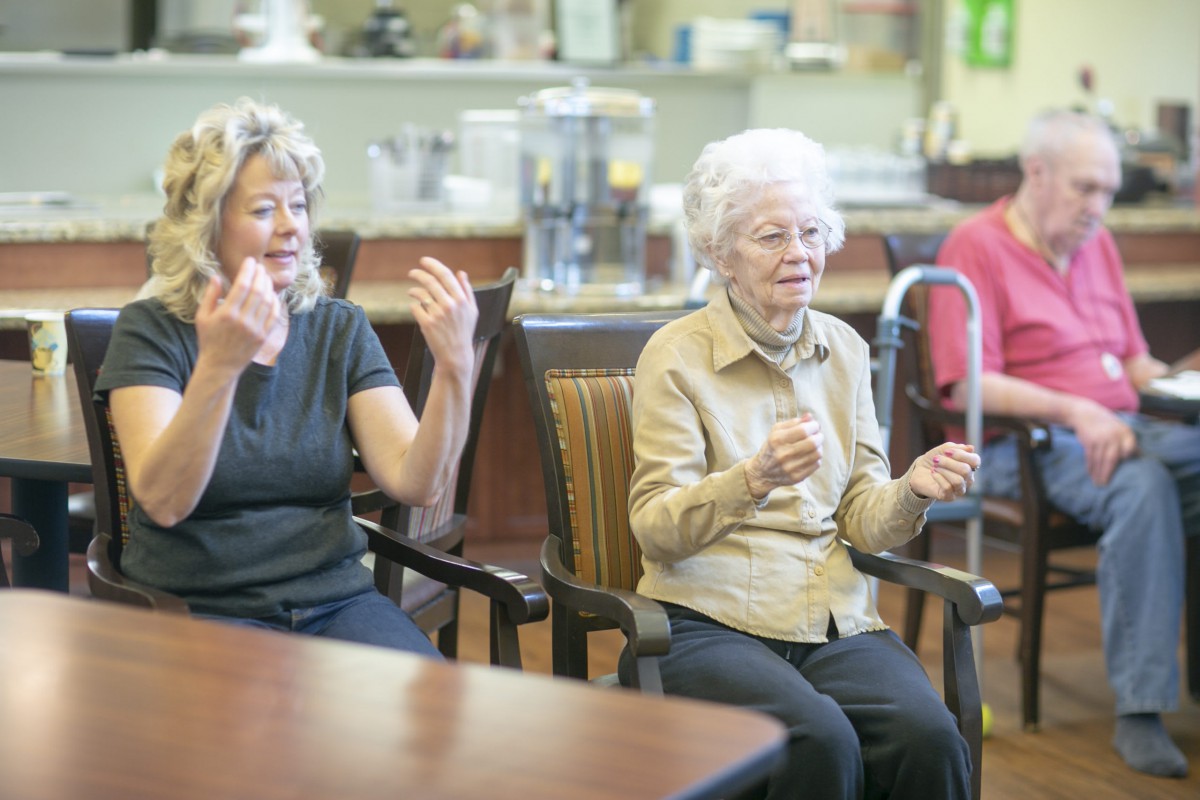 Elderly women participating in a group exercise session indoors.