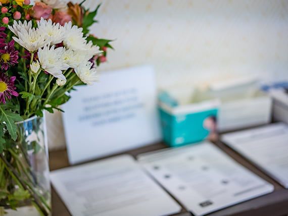 A neatly arranged table with a vase of flowers and various documents.