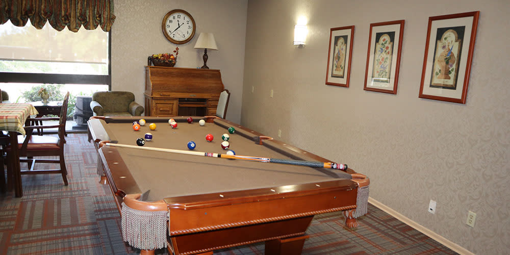 A game room featuring a billiards table with pool balls arranged for play.