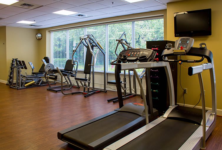An indoor gym with various exercise equipment, including treadmills and strength machines.
