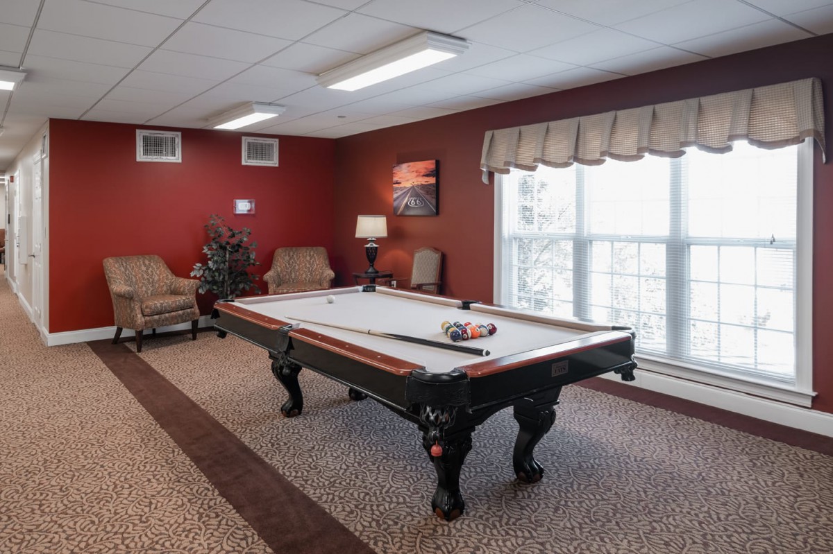 A cozy recreation room featuring a billiard table and comfortable seating.