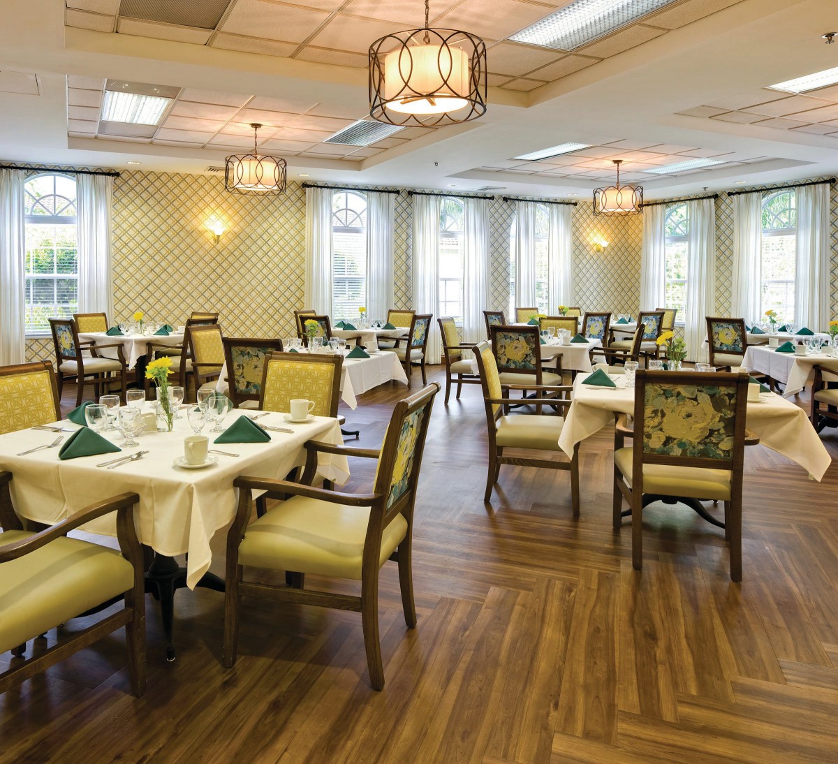 An elegant dining room with neatly arranged tables and chairs, featuring warm lighting and stylish decor.