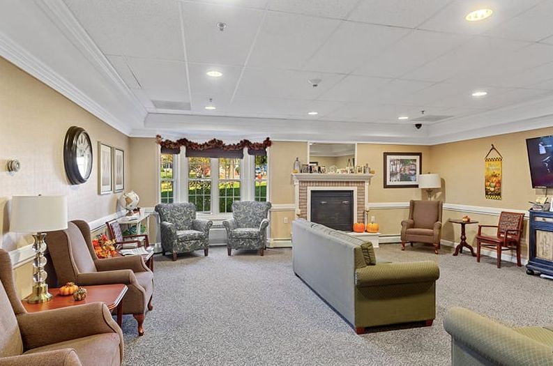 A cozy living room with comfortable seating, a fireplace, and large windows.