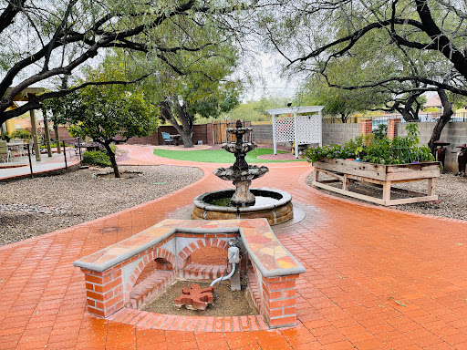 A serene garden pathway featuring a charming fountain and lush greenery.