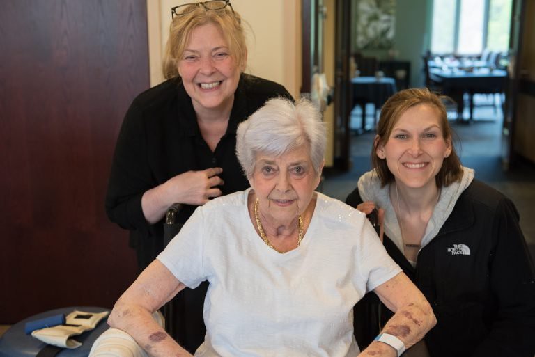 A joyful group photo of three women indoors.