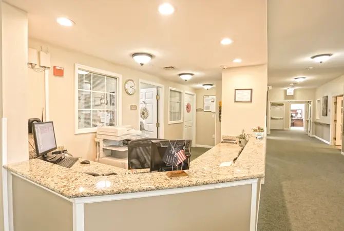 A well-lit reception area with a granite-topped desk and modern office decor.
