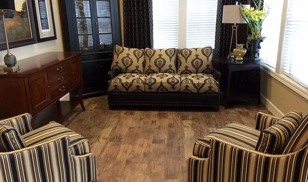A cozy living room with a patterned sofa and wood flooring.