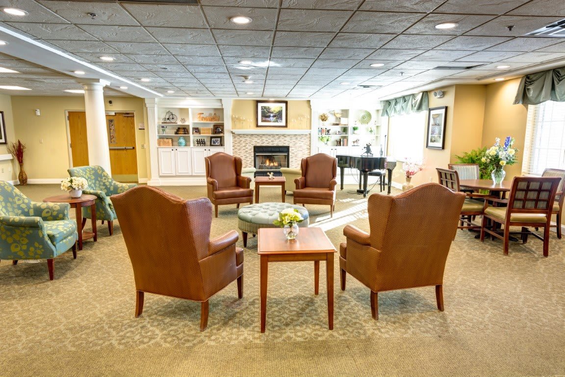 A cozy lobby seating area with chairs, a table, and a fireplace.