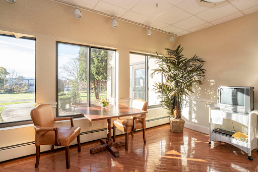 A bright and inviting office space featuring large windows and wooden furniture.