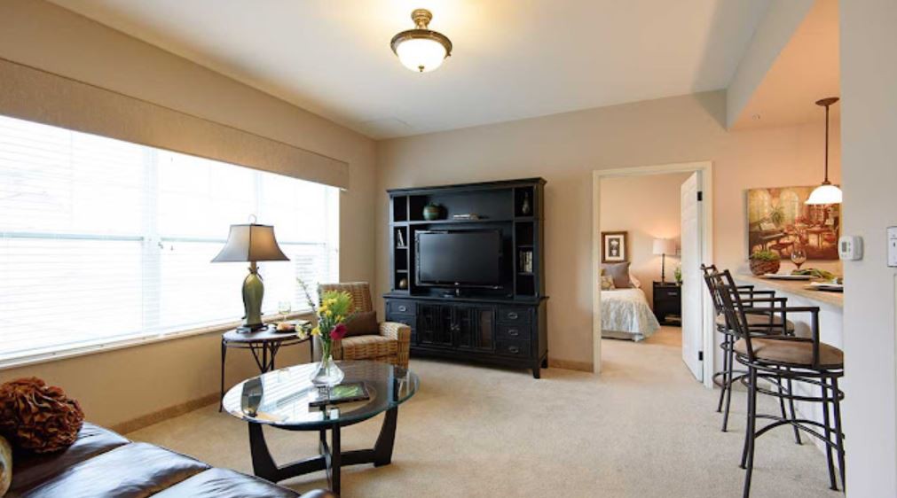 A cozy living room with modern furniture and a television.