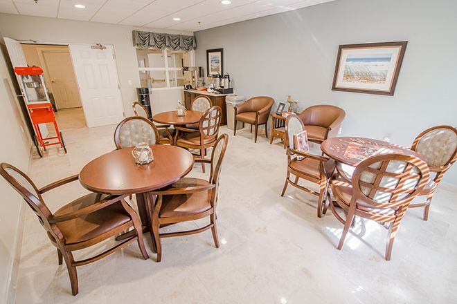A cozy dining area with several tables and chairs, decorated in a cafe style.