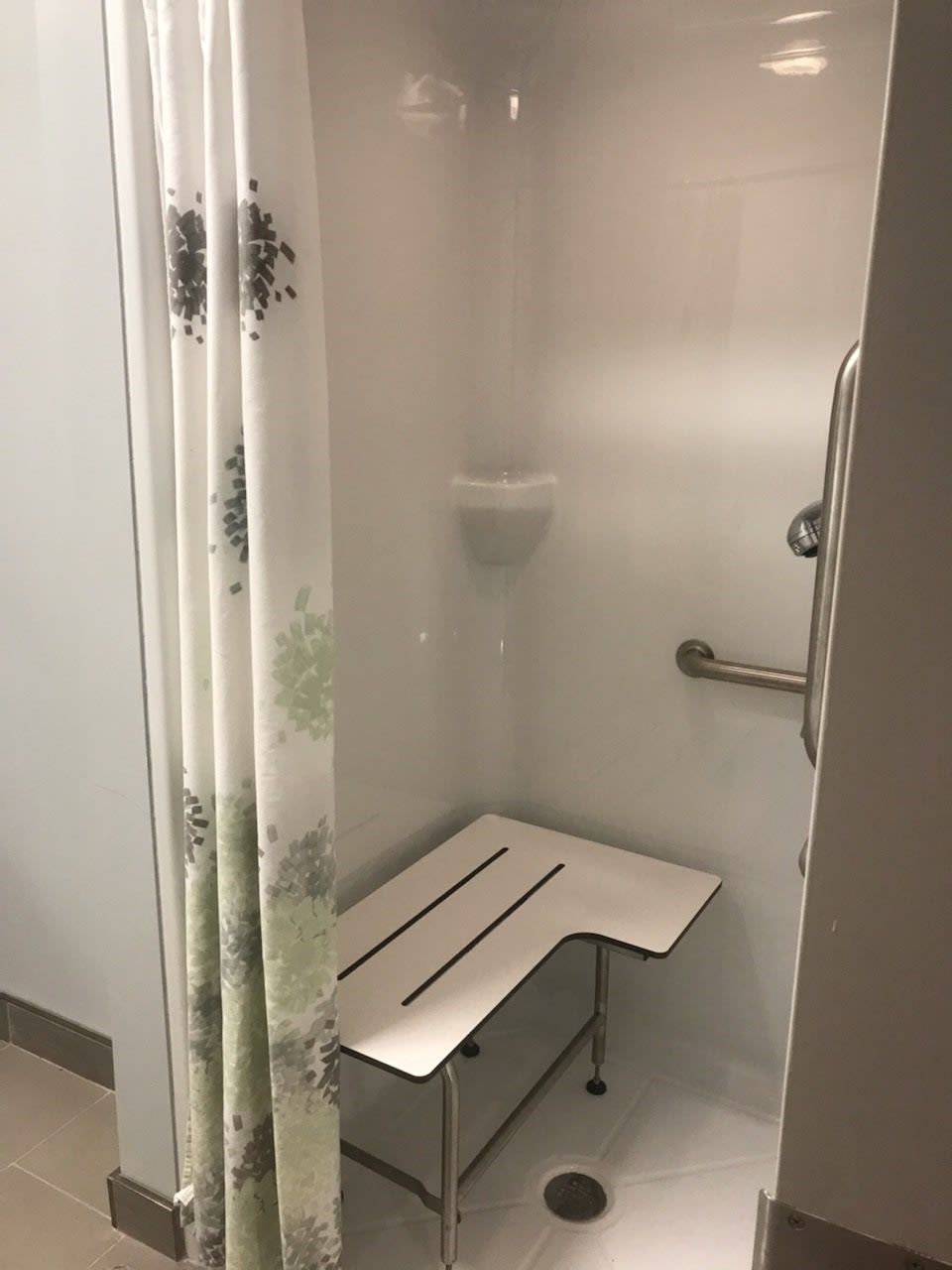 Accessible shower with bench and grab bar.