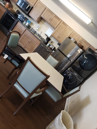 A cozy and functional kitchen dining area featuring modern appliances and a simple table set.