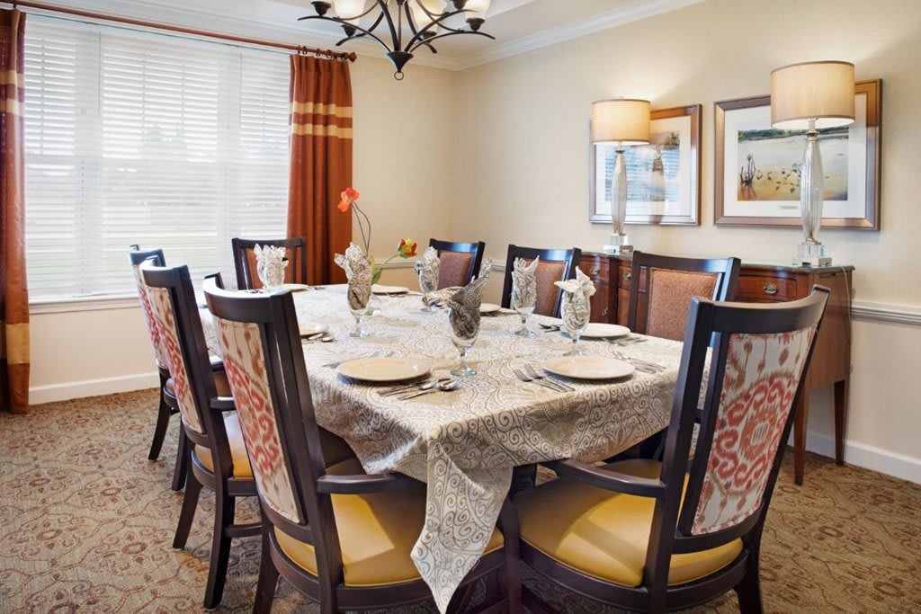 A well-decorated dining room with a set table and elegant chairs.