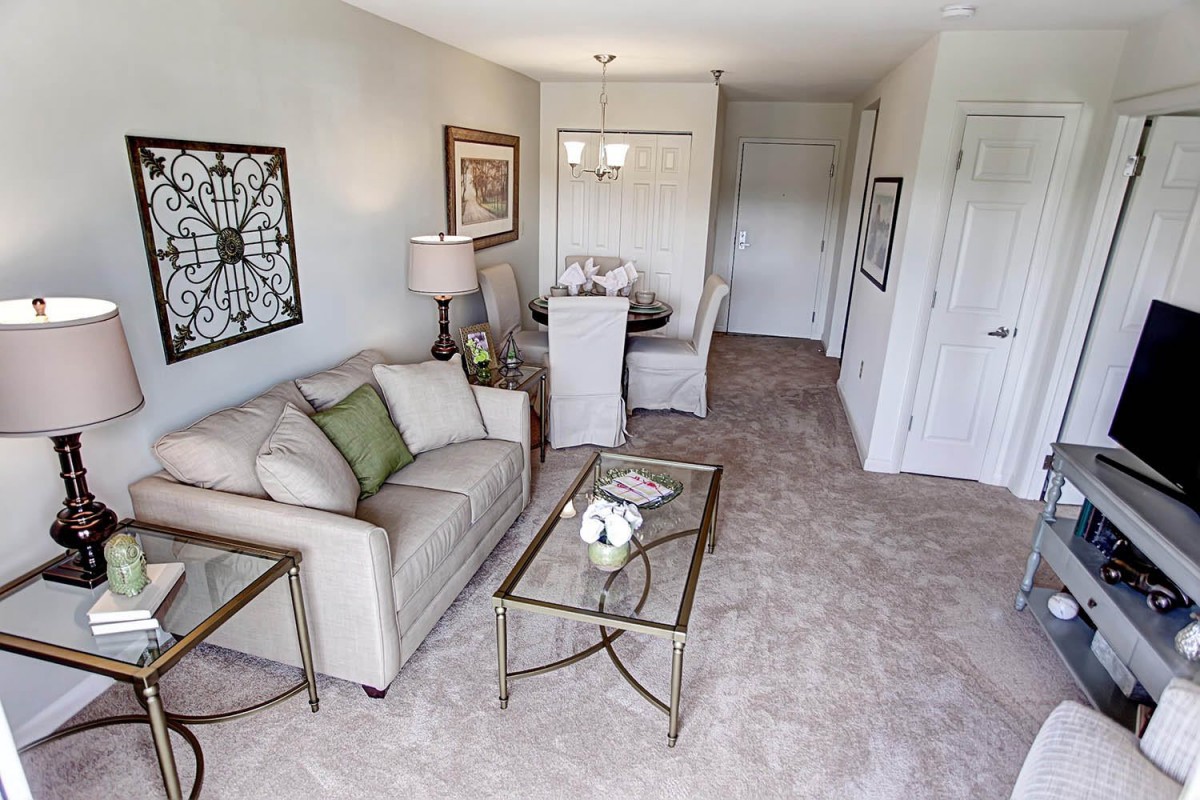 A cozy living room with a connected dining area, featuring elegant furnishings and tasteful decor.