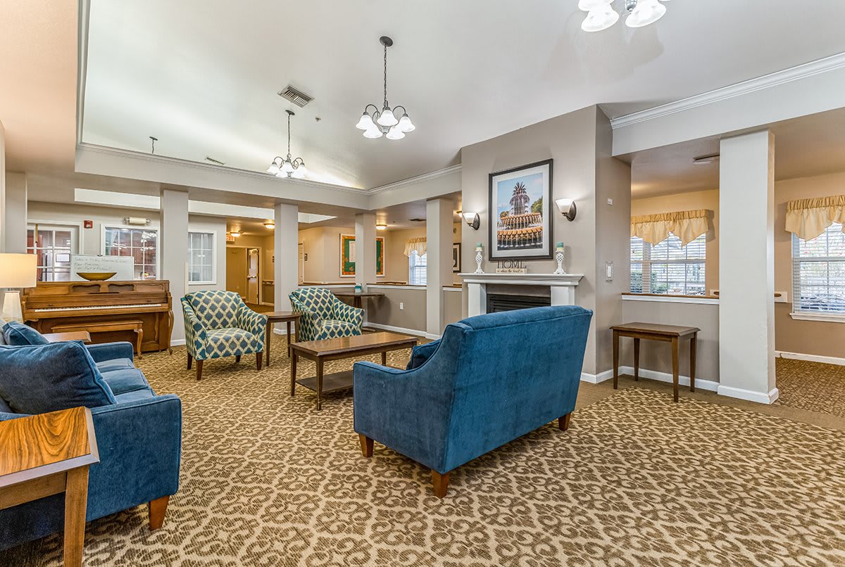 A cozy living room with plush blue chairs and patterned carpet.