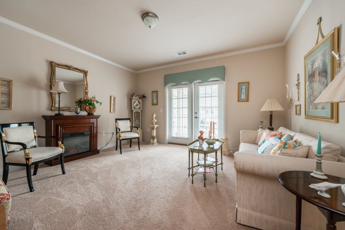 A cozy and traditionally decorated living room with a sofa, fireplace, and elegant furnishings.