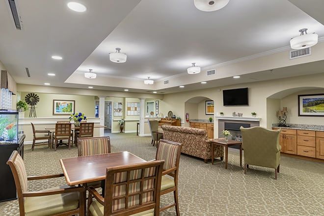 A cozy living and dining area with comfortable seating, a television, and warm lighting.