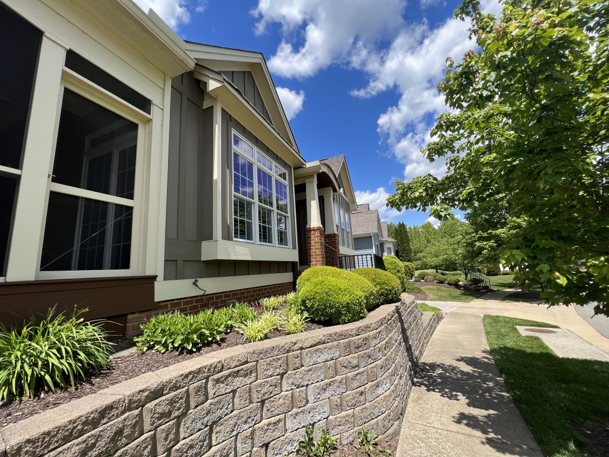 A row of houses with well-maintained gardens under a bright, sunny sky.