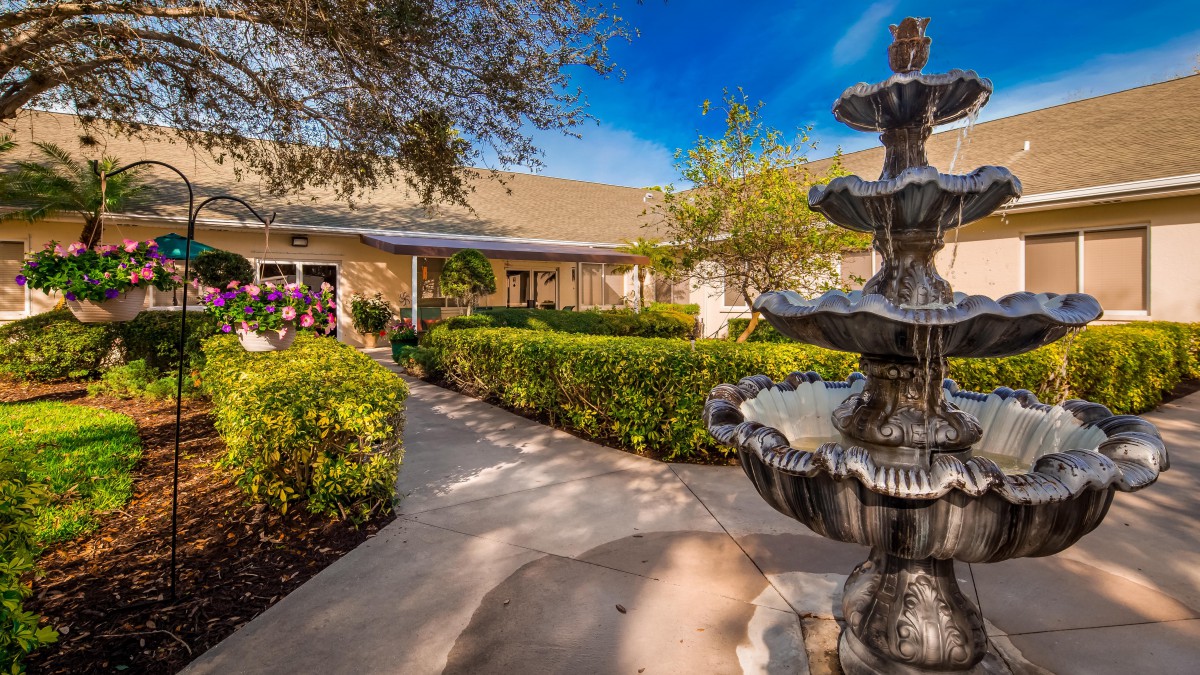 A charming house with a well-maintained garden and a decorative fountain along the pathway.
