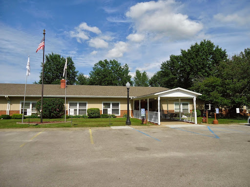 A welcoming community center surrounded by greenery and a clear blue sky.