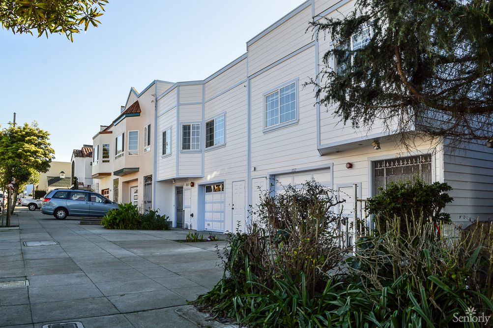 A row of suburban houses with driveways and front gardens.