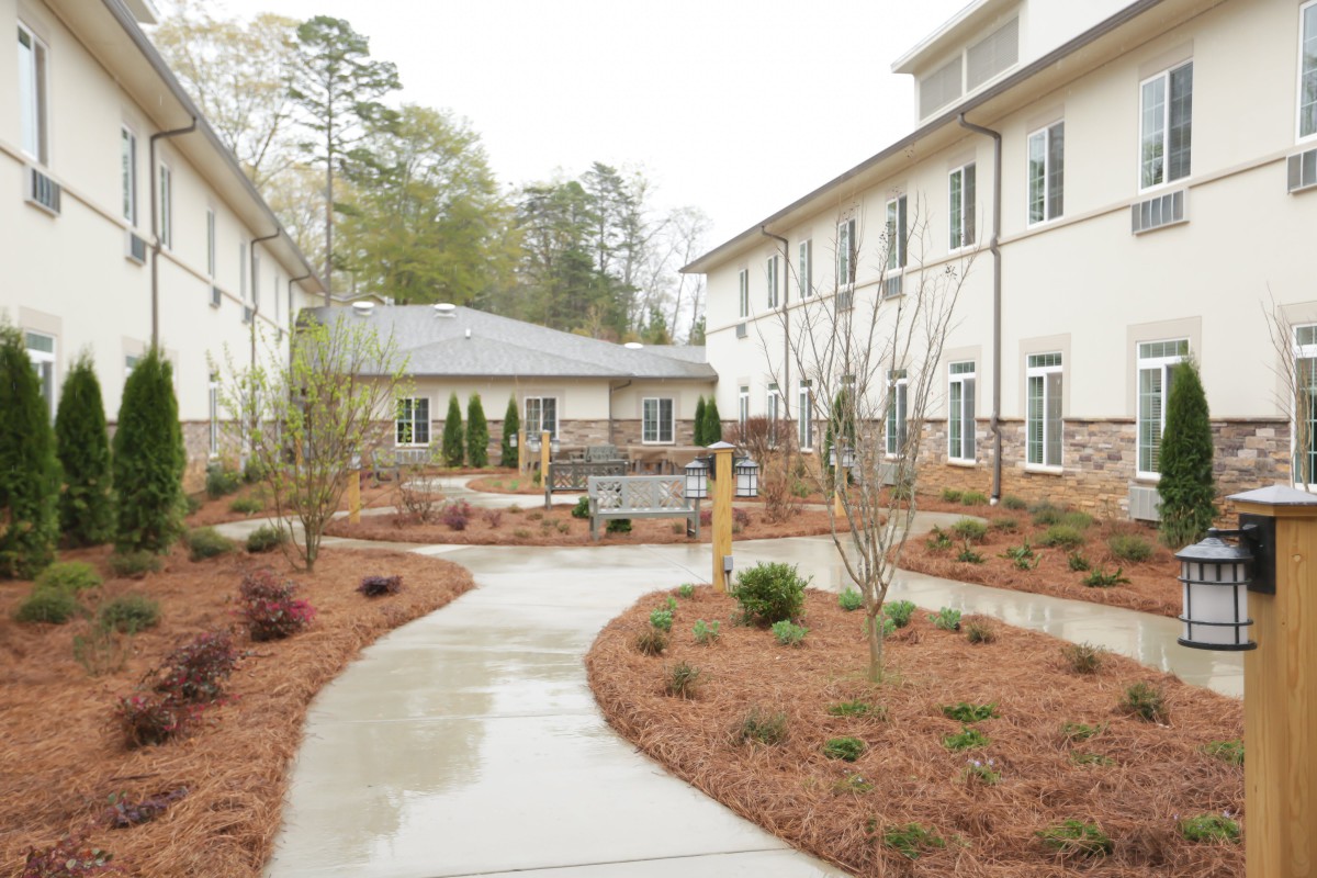 A serene outdoor view of a landscaped garden in between two buildings.