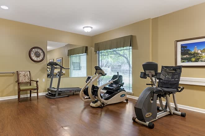 A small gym with exercise equipment including treadmills and stationary bikes.