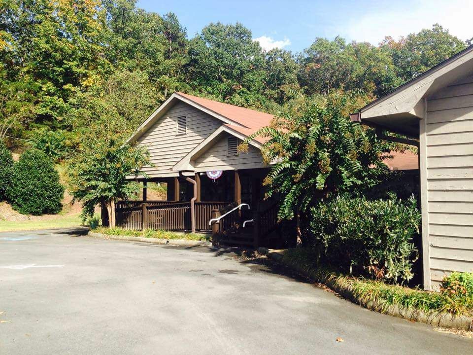 A quaint cabin nestled among lush greenery and trees.