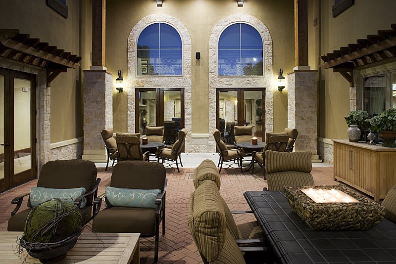 A cozy lounge area with comfortable seating and large arched windows.