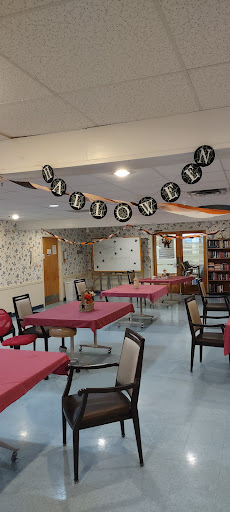 A decorated dining area ready for a Halloween celebration, featuring festive banners and set tables.