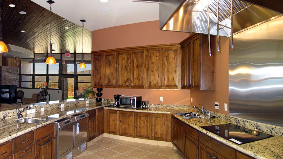 A modern kitchen featuring wooden cabinets, stainless steel appliances, and granite countertops.