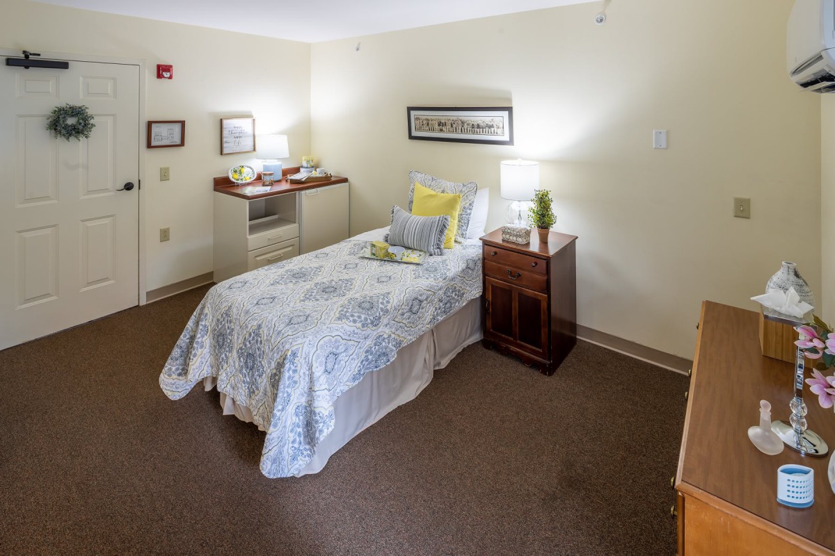 A cozy bedroom with a single bed, nightstand, and decorative elements.