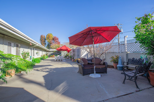 A serene outdoor patio area featuring red umbrellas and comfortable seating, perfect for relaxation.