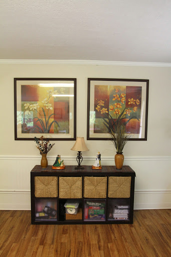A cozy living space featuring framed artwork and decorative accents on a console table.