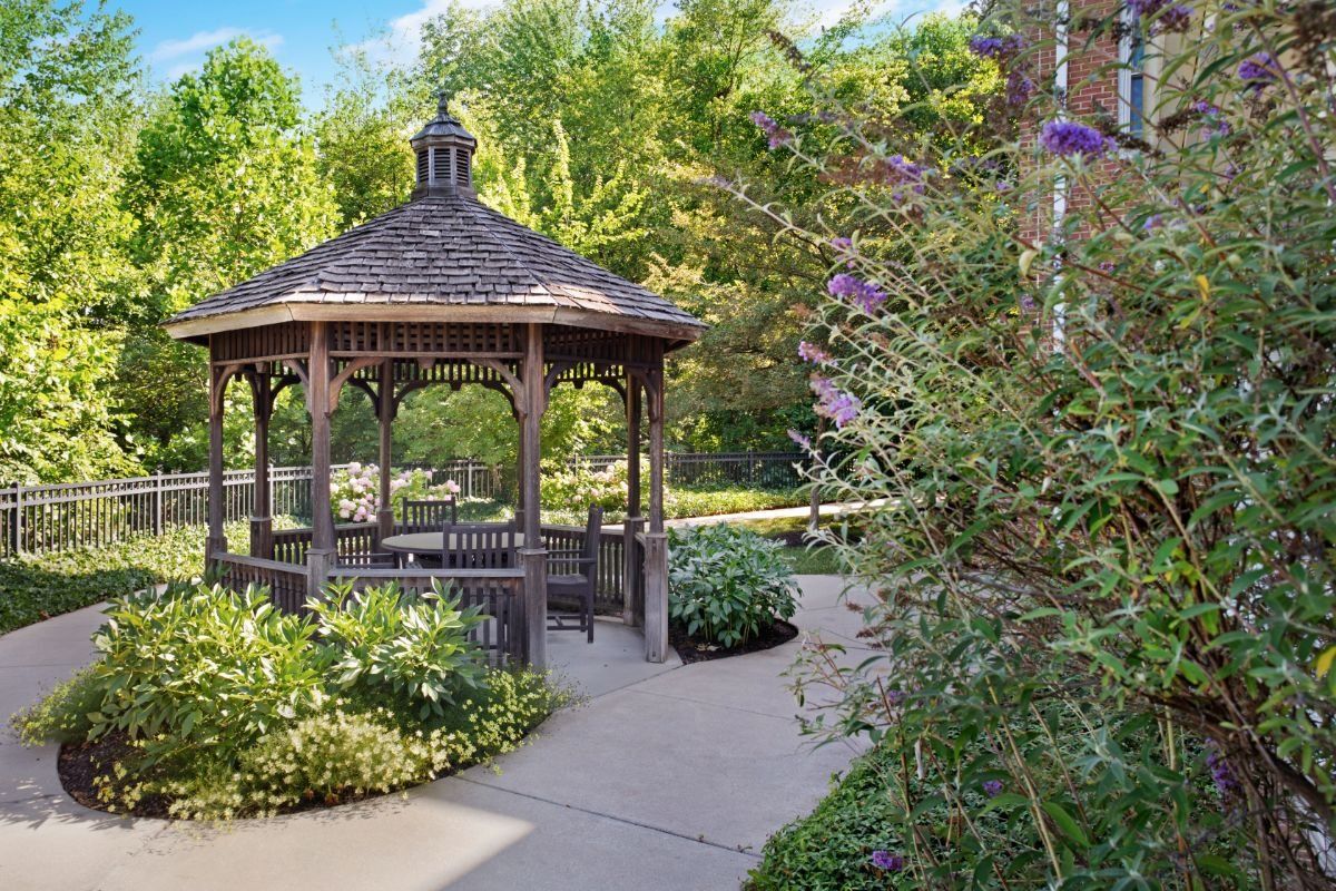 A charming gazebo surrounded by lush greenery in a serene garden setting.