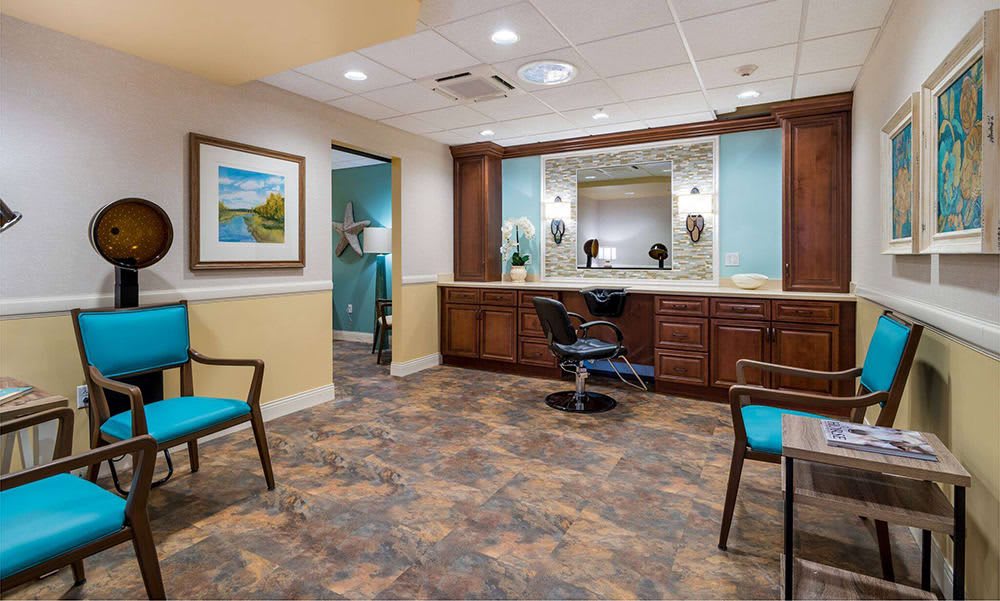 A cozy hair salon with stylish decor, featuring chairs, a large mirror, and warm lighting.